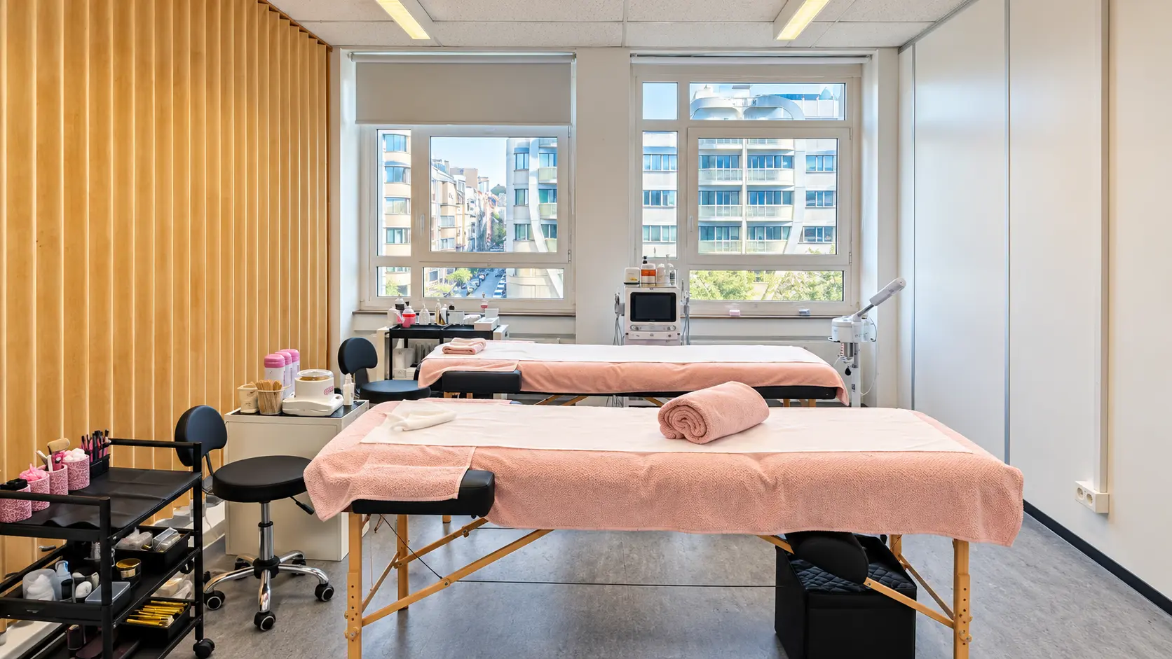 Cabines de soins avec tables de soin habillées de rose